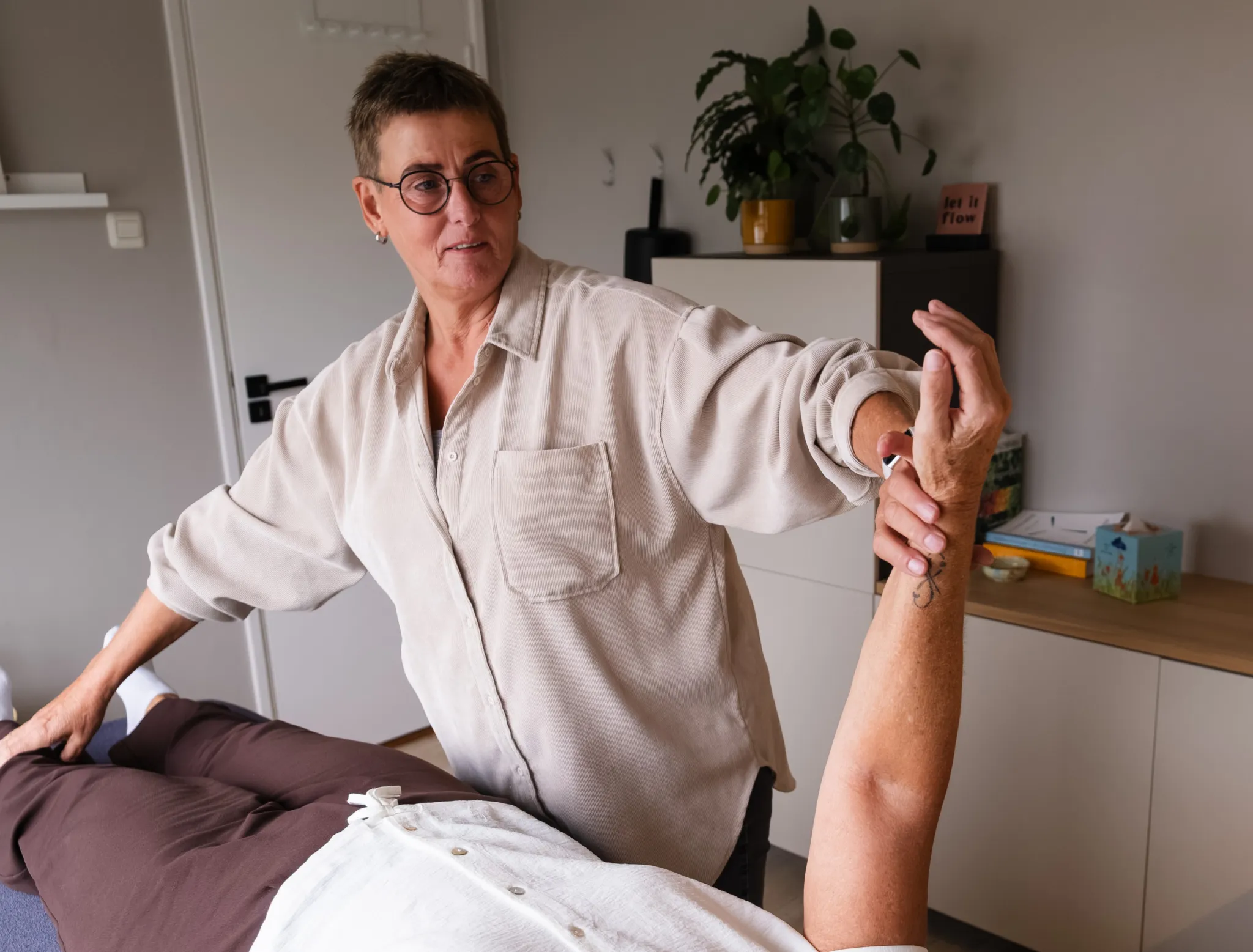 Thea van Holten-Terlouw voert een spiertest uit in haar praktijk